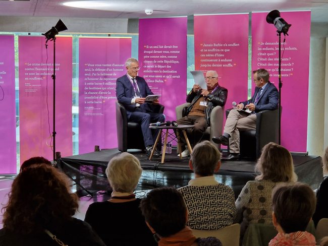 Dominique Vidaud (directeur de la Maison d’Izieu), Alexandre Halaunbrenner (deux de ses soeurs, Claudine et Mina, font partie des 44 enfants raflés à Izieu) et David Chabin (professeur de philosophie au Lycée Ampère, Lyon, modérateur du colloque) durant le colloque “Les mères dans la Shoah” le 15 octobre 2023 / Dominique Vidaud (Maison d’Izieu’s director), Alexandre Halaunbrenner (two of his sisters were part of the 44 children rounded up at Izieu) and David Chabin (philosophy teacher at the Lycée Ampère, Lyon, the symposium moderator) during the symposium “Mothers in the Holocaust” on October 15 2023 © Maison d’Izieu